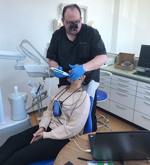 Dentist performing in depth dental screening
