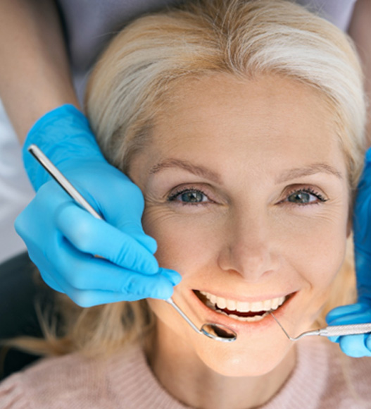 Dentist and female patient smiling 
