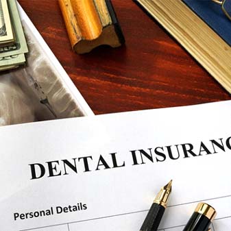 Dental insurance form next to money, X-Ray, and book
