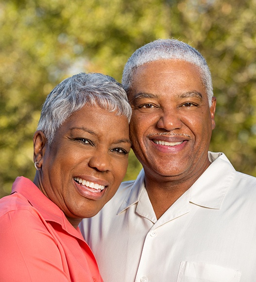 Man and woman with healthy smiles after restorative dentistry