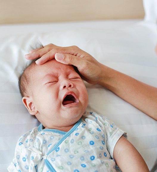 Crying baby in need of lip and tongue tie treatment