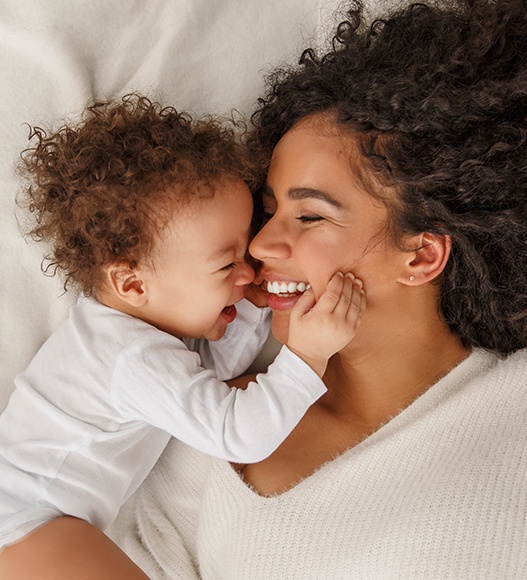 Mother and baby smiling after frenectomy treatment