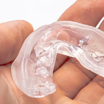 Hand holding clear sports mouthguard