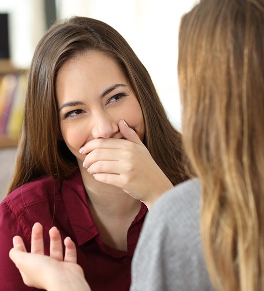 Woman in need of Lumineers hiding smile behind her hand