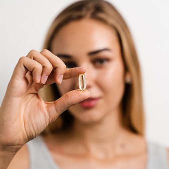 woman holding a pill 