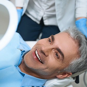 Happy patient admiring the results of his cosmetic dentistry treatment