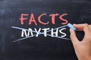 Chalkboard illustrating difference between facts and dental implant myths