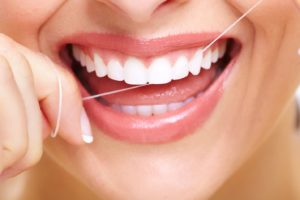Close-up of woman’s beautiful smile as she is flossing