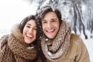 Couple playing in snow, successfully dealing with winter mouth issues