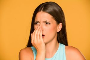 Woman covering mouth, embarrassed by coffee breath