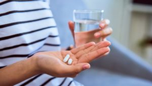 young woman taking two pills 