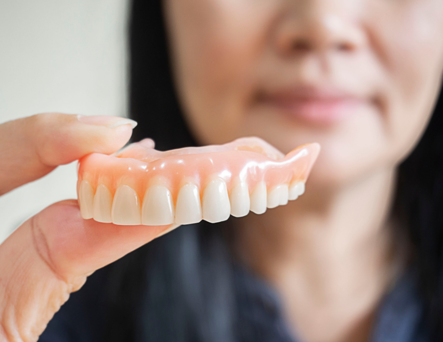 Woman holding denture